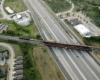 Big Boy steam locomotive hauls a passenger train over a major highway.