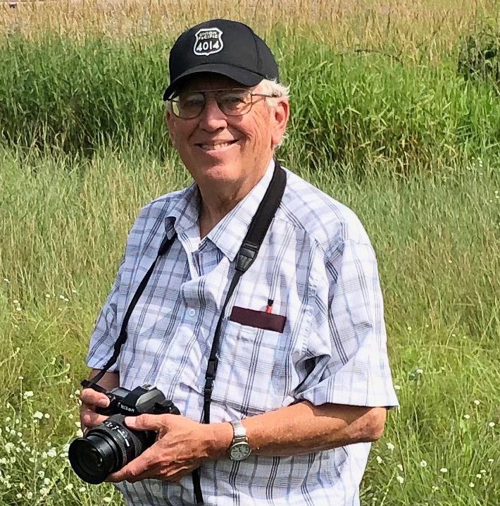 Man in black cap with camera