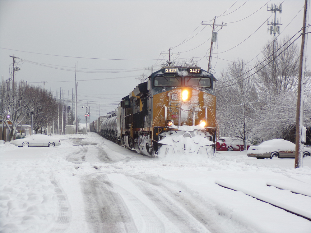 Train running down street in snow