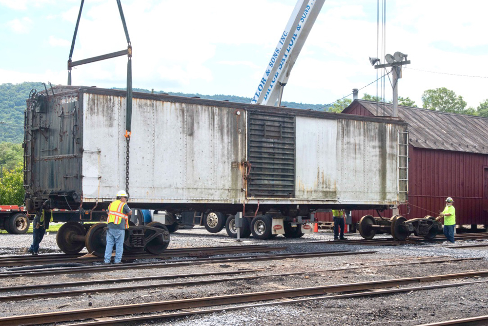 Boxcar being lowered by cranes