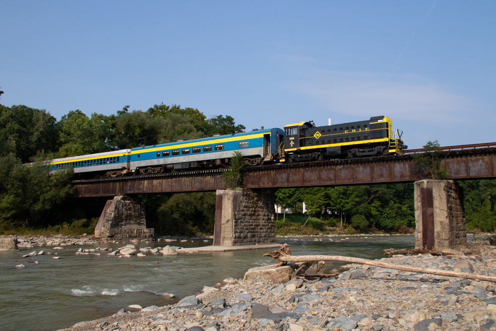 Black and yellow locomotive pulling passenger cars