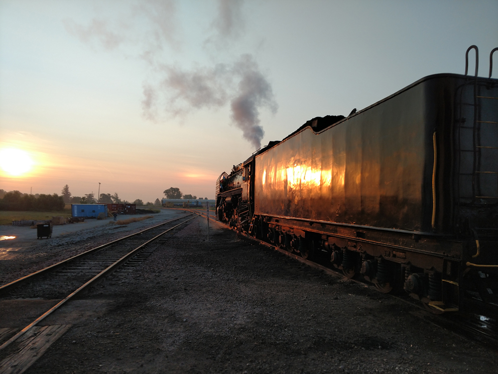 Rising sun reflecting on side of locomotive