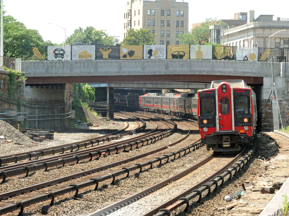 Electric commuter train passing under bridge