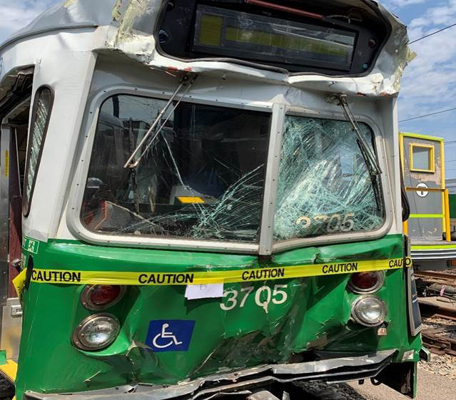 Smashed-in front of green and white light rail vehicle