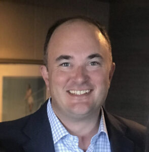 Smiling man in coat and open-collared shirt