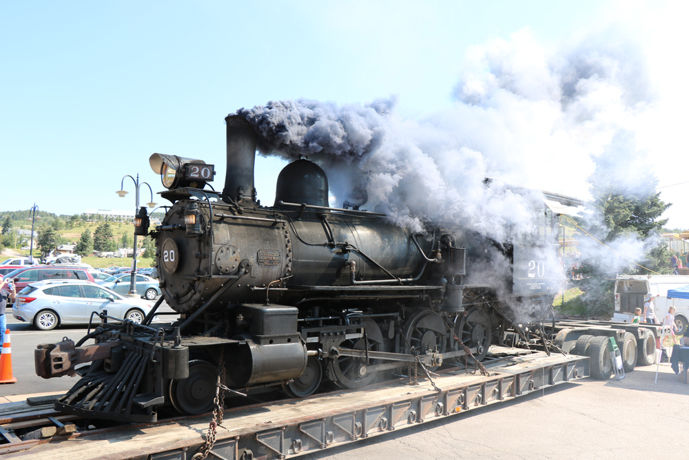 Smoke comes from stack of locomotive on trailer