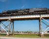 Viewing a large steam locomotive on a bridge from below.