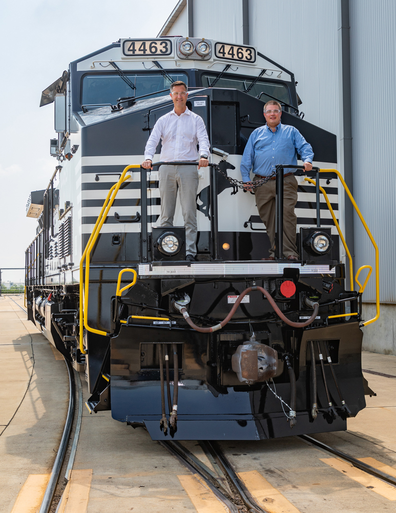 Two men standing on front platform of locomotive