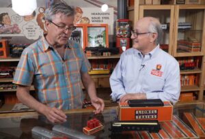 John Truckenbrod and Roger Carp with a small set of red wooden barrels.