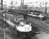 High-angle view of streamlined diesel and electric locomotives on parallel tracks.