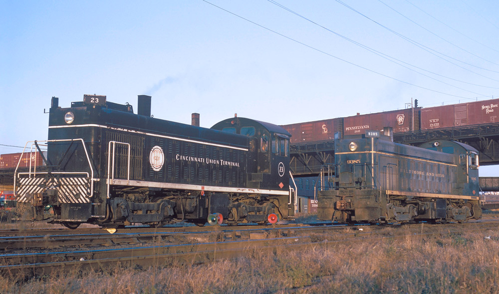 Three-quarter color photo of two diesel shunting locomotives on adjacent tracks.