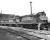 Black-and-white three-quarter view of three diesel road-switcher locomotives coupled together.