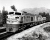 Three-quarter-angle black-and-white photo of Union Pacific two-unit gas-turbine electric locomotive on freight train.