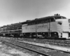 Black-and-white three-quarter-angle photo of three-unit streamlined diesel locomotive.