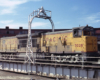 Broadside color photo of Union Pacific road-switcher diesel locomotive on turntable.