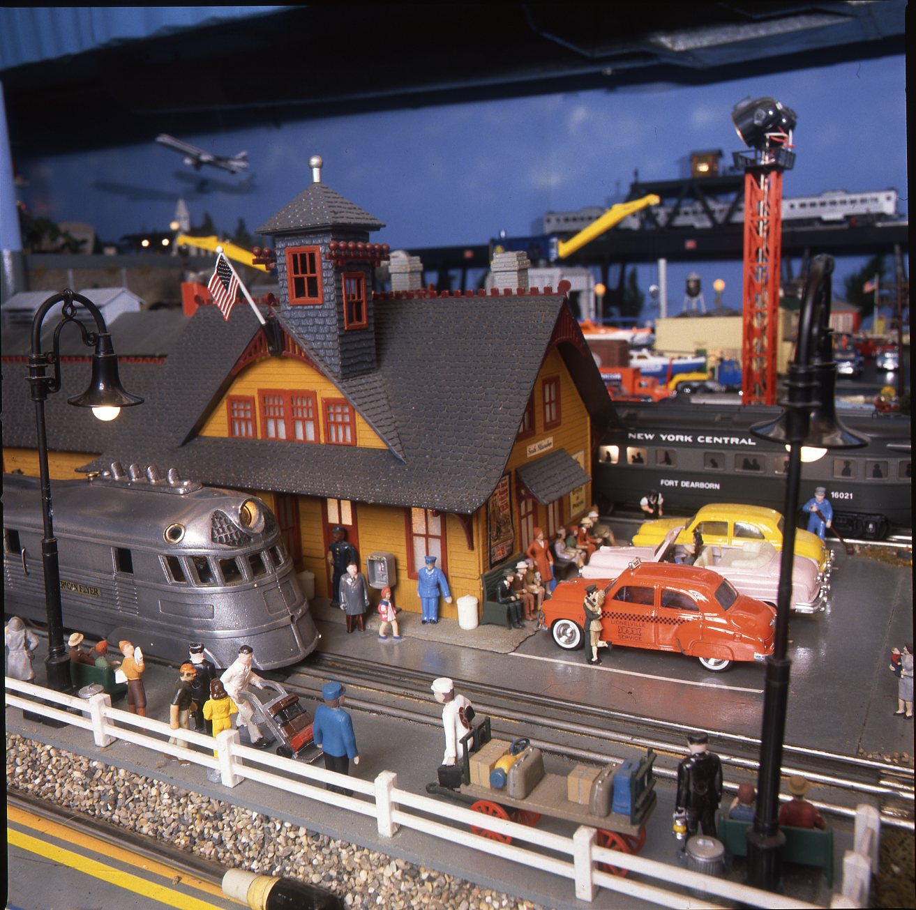 A busy station scene on an O gauge layout.