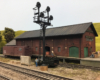 Railroad men work on the loading dock at a brick freight house where a boxcar sits