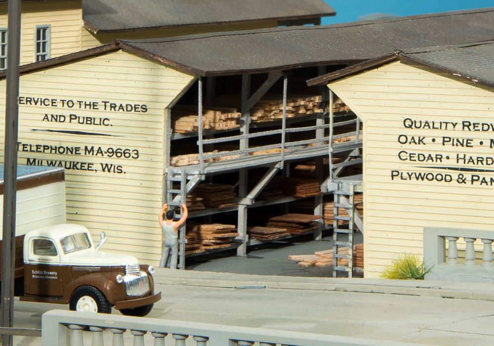 Stacks of real wood lumber are seen in a rack at an HO scale lumber yard