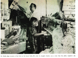 Vintage photo with man and girl near model railroad