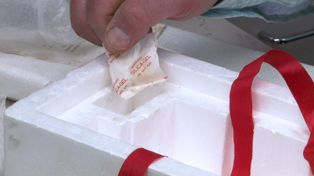A silica gel packet held between two fingers.