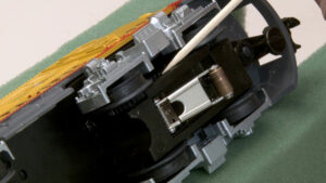 Applying oil to a locomotive truck axle with a needle applicator.