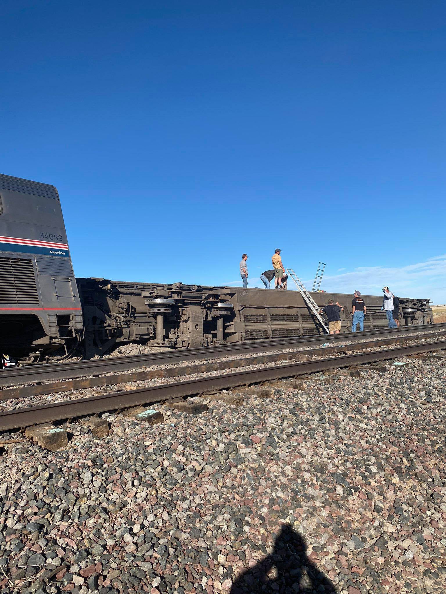 Man on passenger car turned on its side