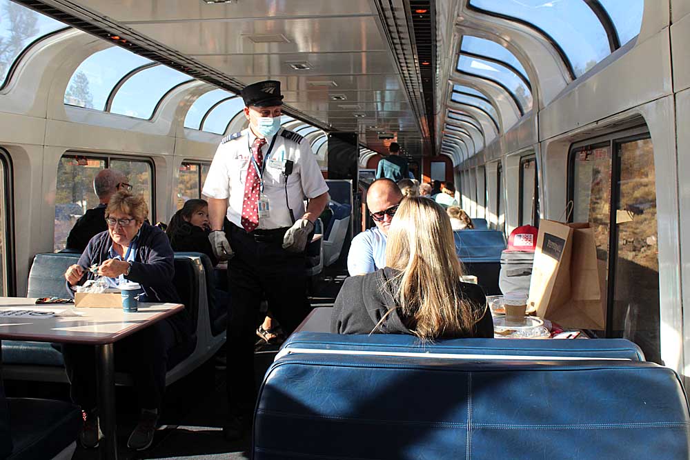 People in glass-covered passenger rail car