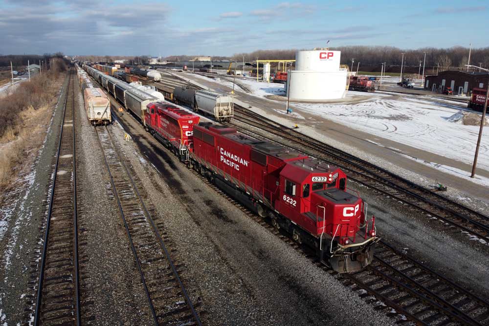 Red diesel locomotives with cars in yard