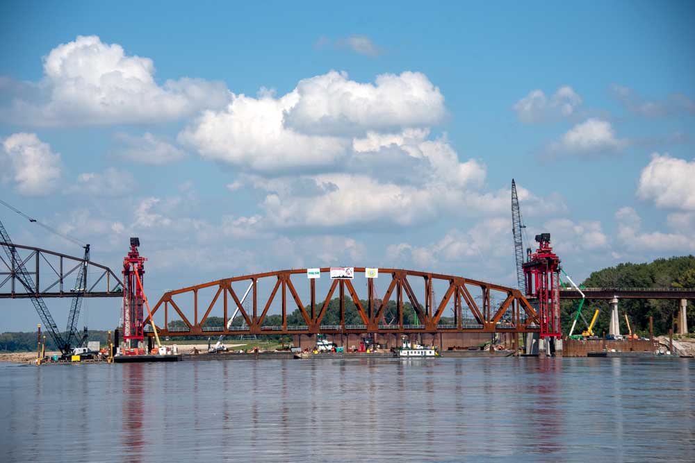 Bridge trusses lifted into place over waterway