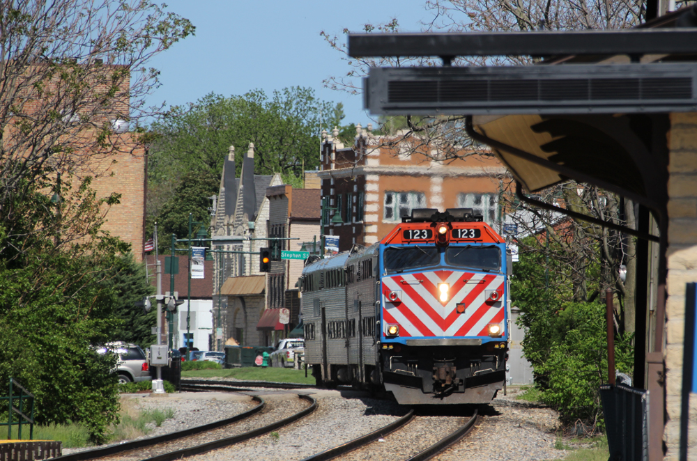 Commuter train rounds curve with buildings in background