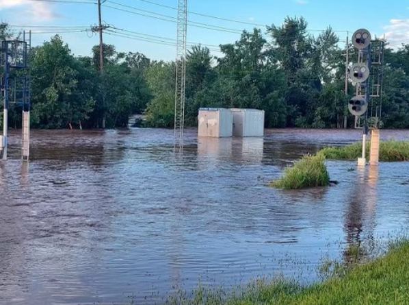 Rail signal rising above large area of water