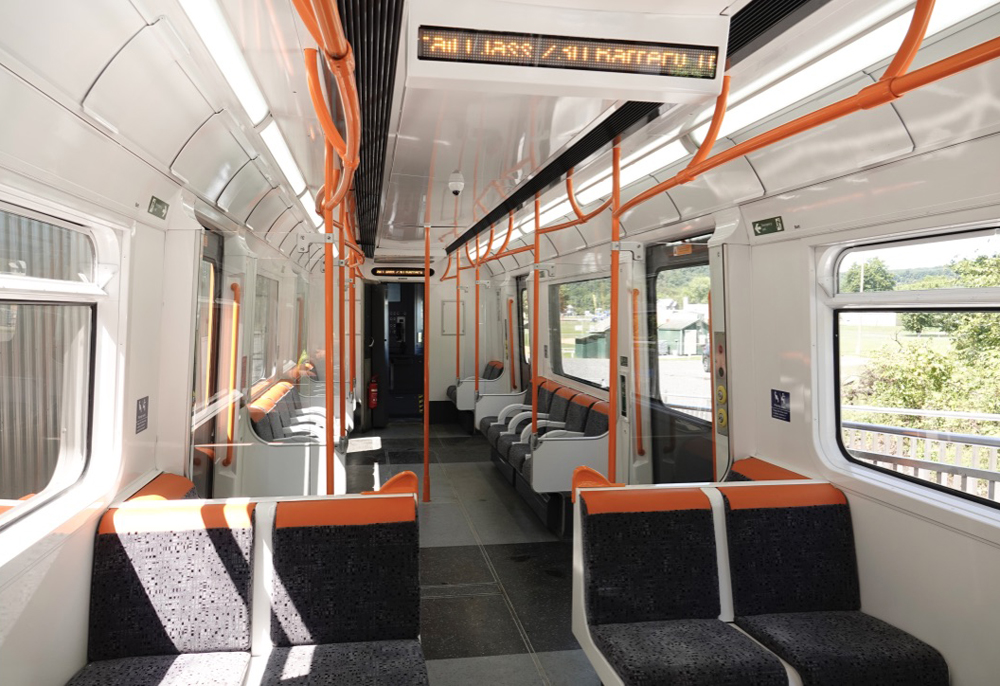 White passenger car interior with black seats and orange trim