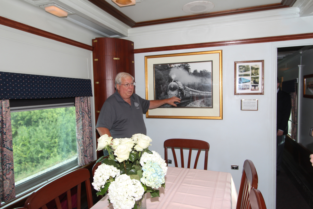 Man gesturing to framed photo inside private car