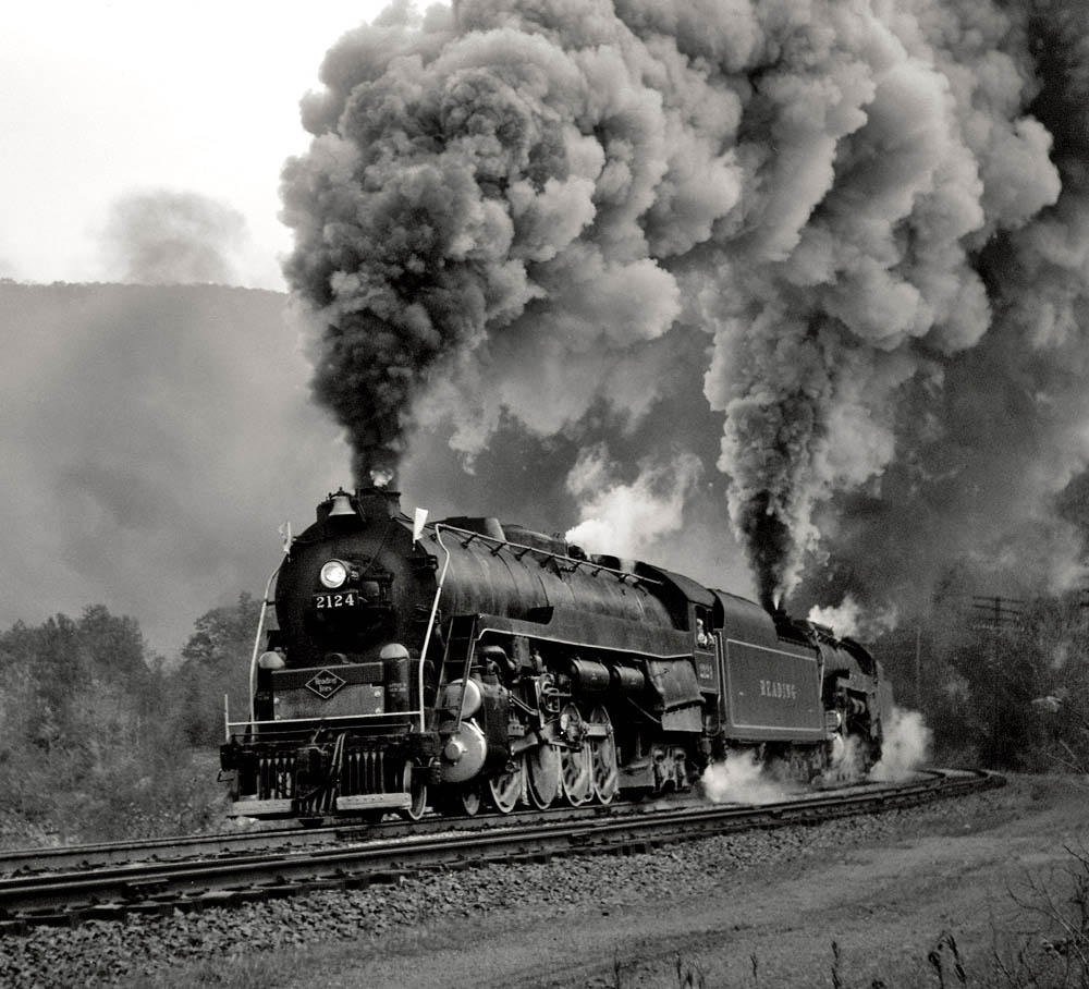 Black-and-white three-quarter angle photo of 4-8-4 steam locomotive in action