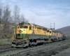 Color photo of three road-switcher diesel locomotives with Reading Company freight train