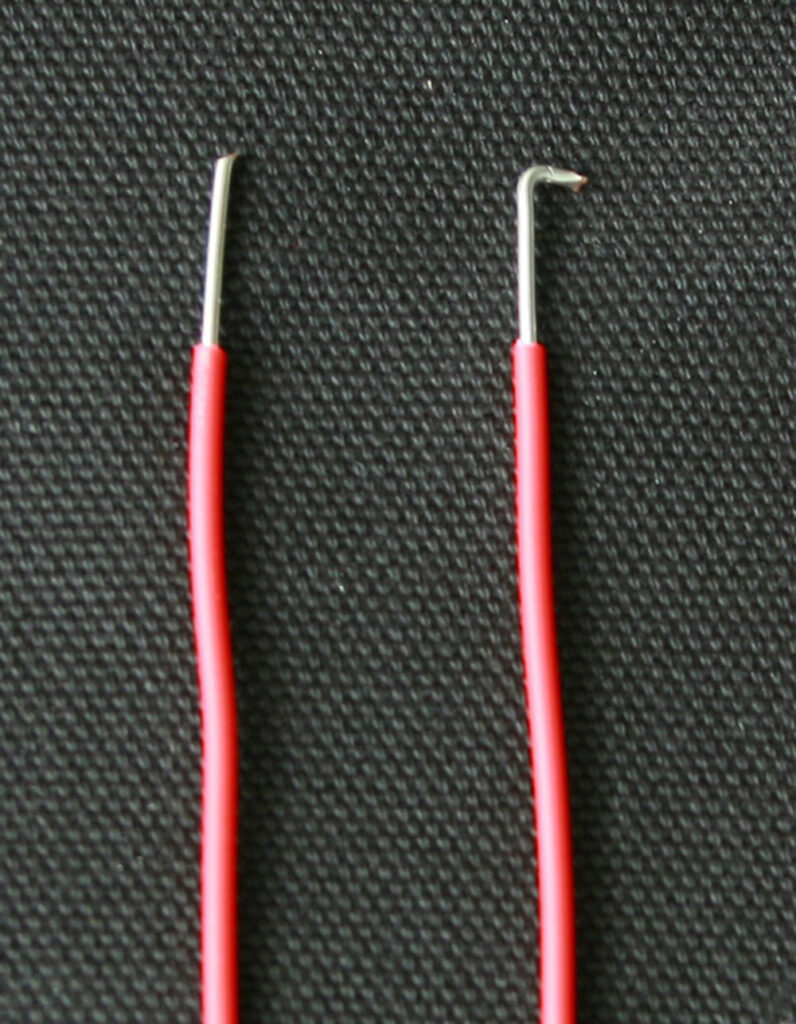 Two wires side by side, one stripped on the end and one bent on the end.