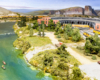 A broad, green river flows past a roundhouse and locomotive servicing terminal where yellow-and-gray locomotives ride the turntable