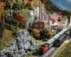 A reefer train and a coal drag pass each other near a paper mill in the West Virginia mountains