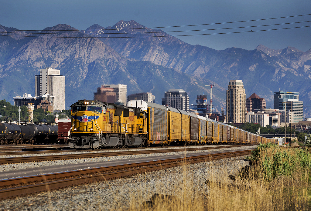Train with yellow diesels against skyline and mountains