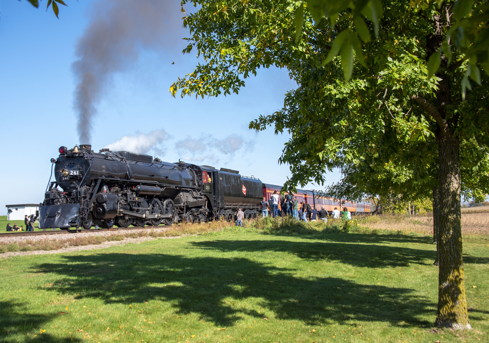 People gather around steam locomotive and train