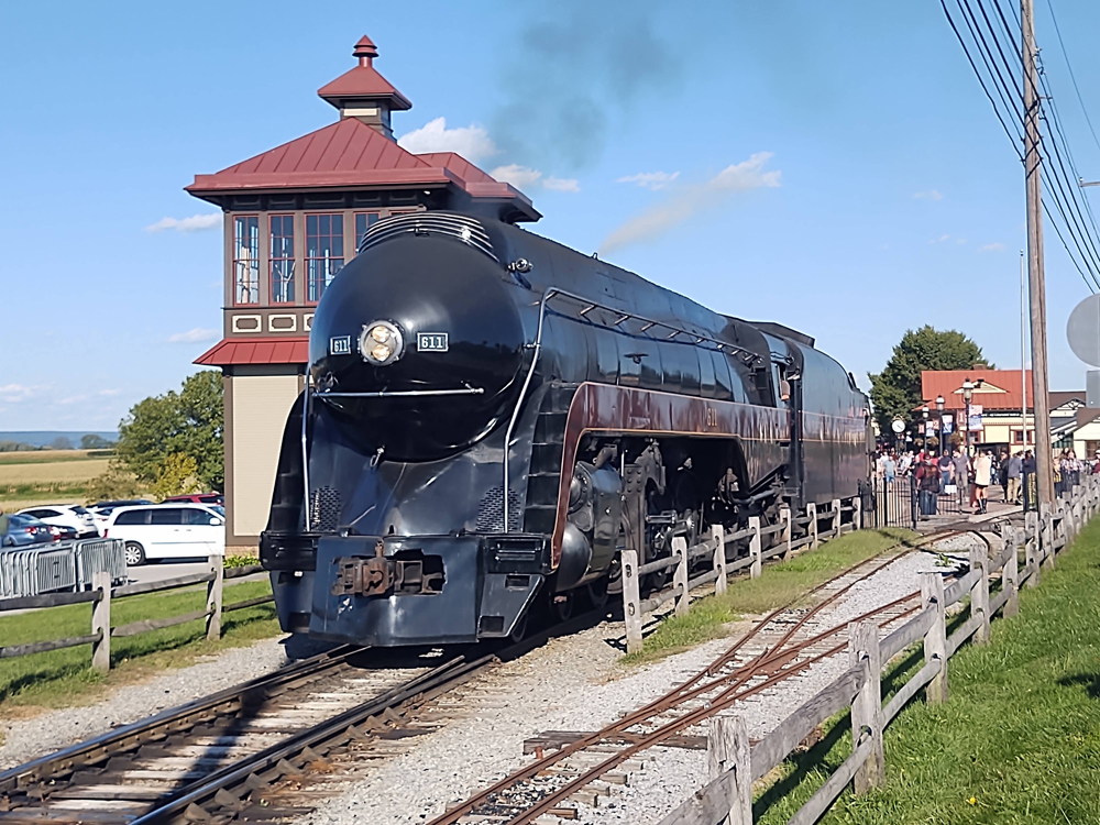 Streamlined steam locomotive at station next to tower