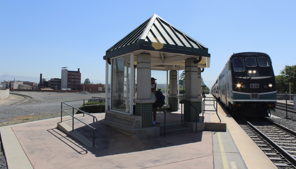 Commuter train, with cab car leading, arrives at station platform