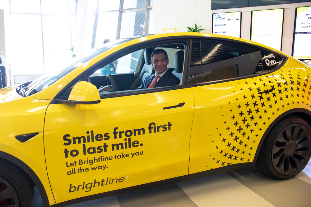 Man in suit behind the wheel of bright yellow car
