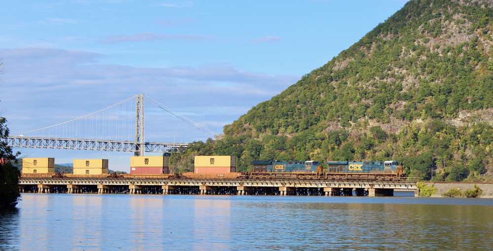 Train on bridge along river