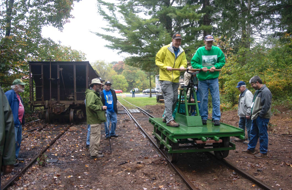 Men ride handcar as others look on