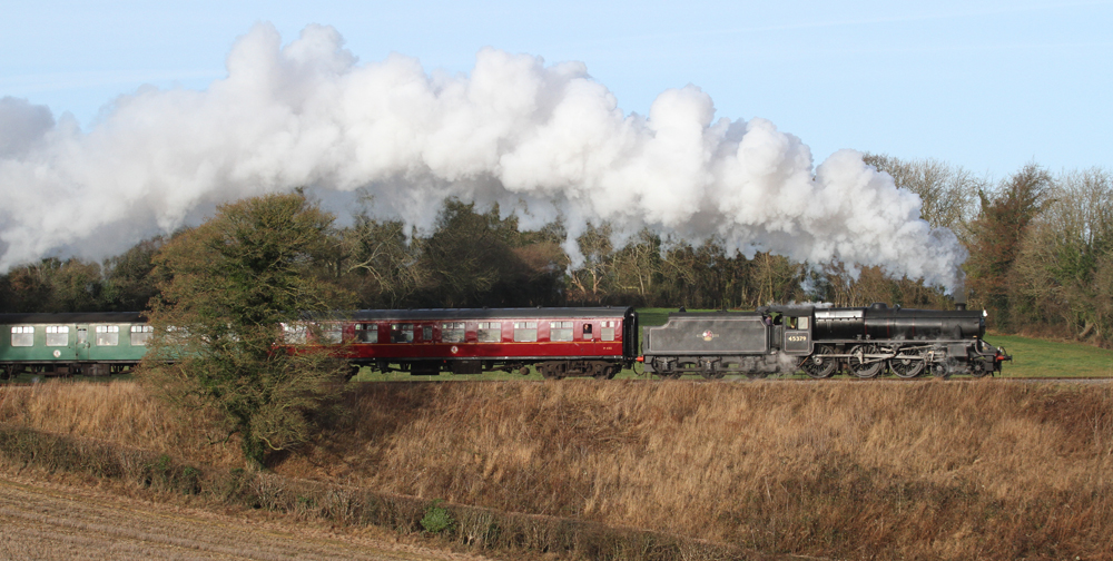 Side view of British steam locomotive and train