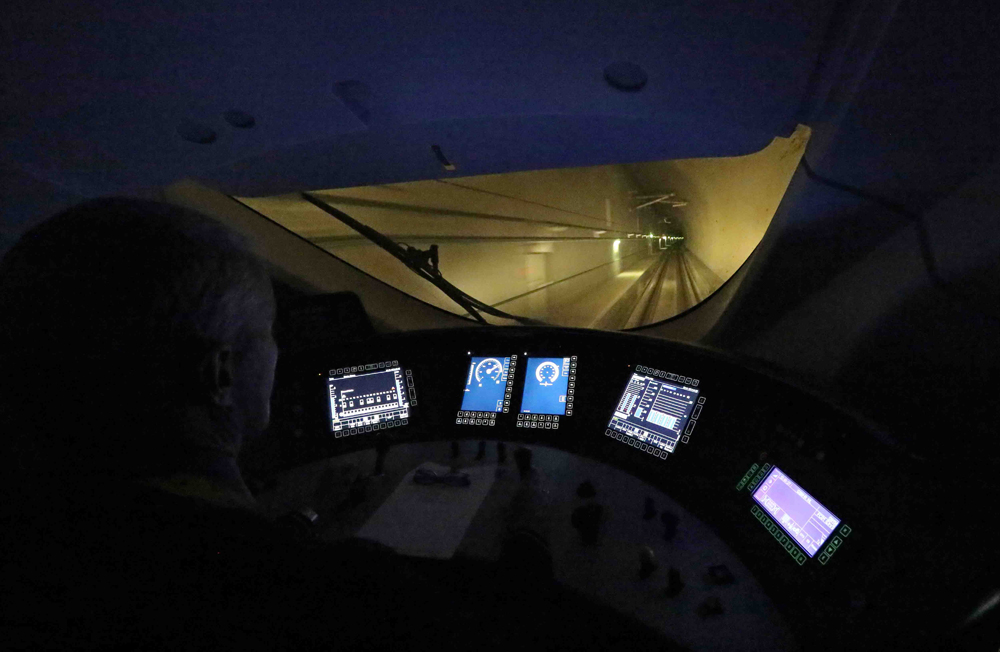 Darkened interior of locomotive cab in tunnel with various video screens