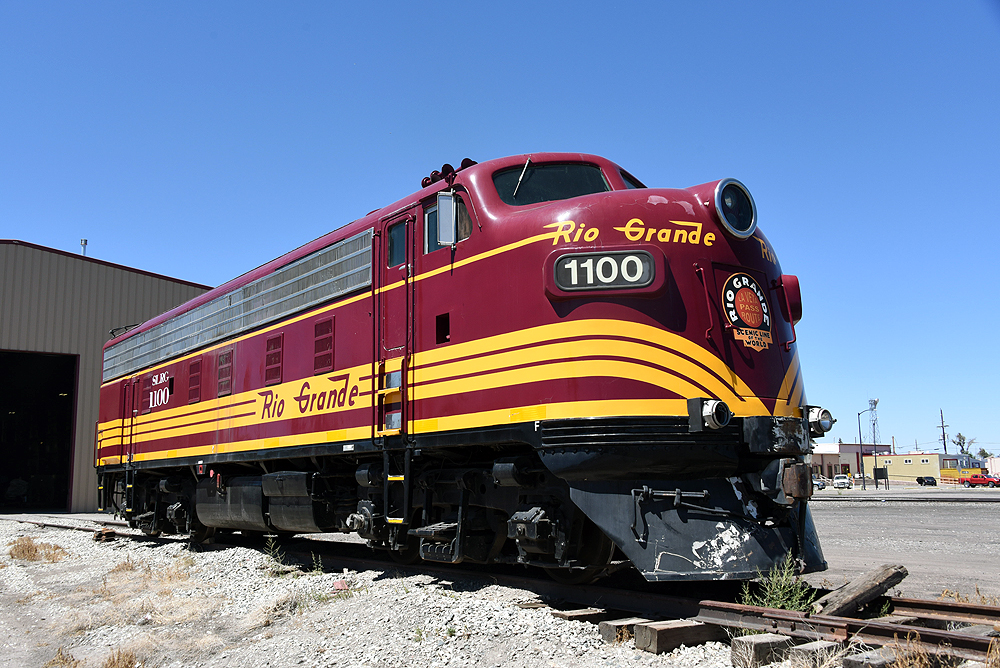A maroon and yellow-stripped cab unit under clear, sunny skies.