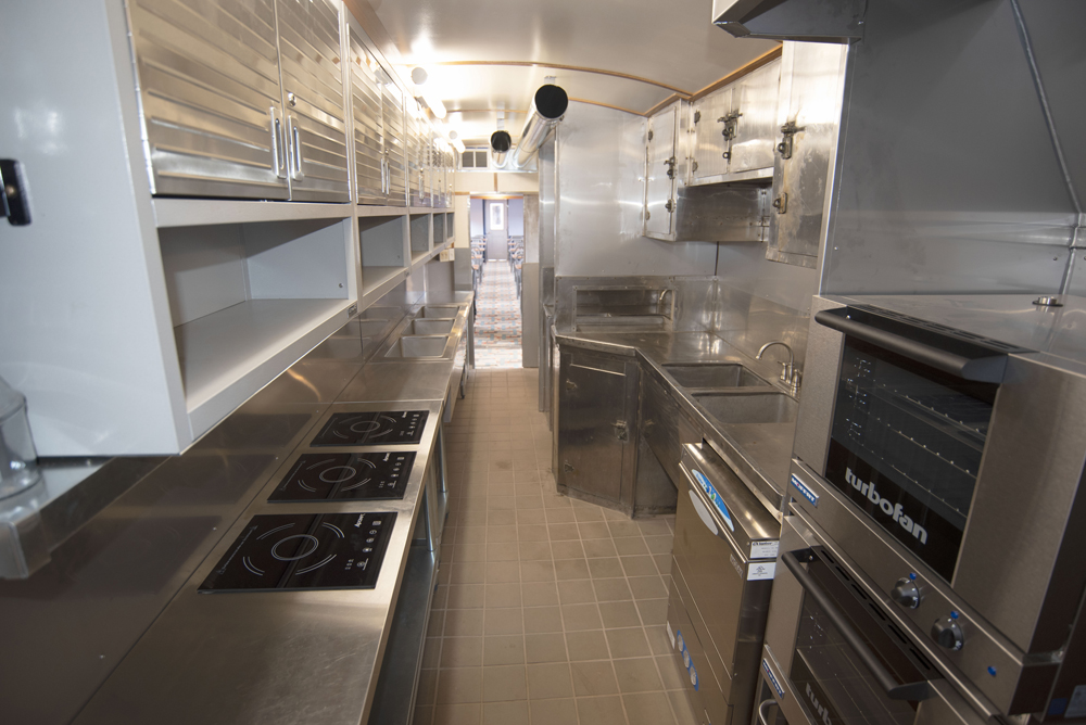 Kitchen in railroad car, with new equipment on one side and original equipment on the other