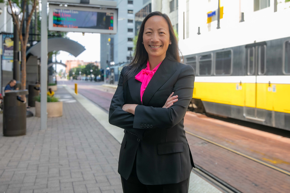 Woman standing next to light rail line